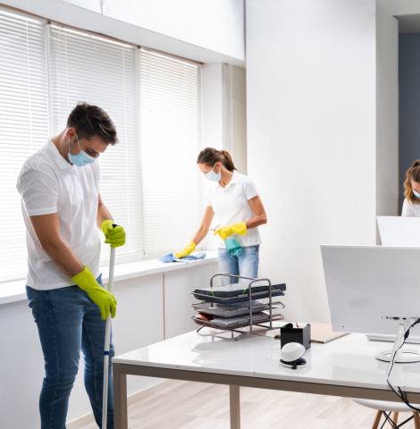 Two people cleaning an office space.